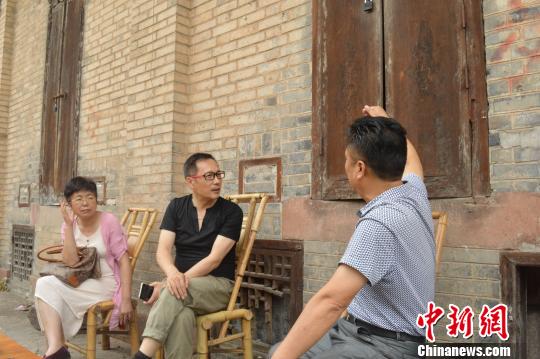 导演山奇与邛崃老粮站职工攀谈。　廖雪芝 摄