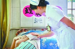 护士长巡房时与患者交流。