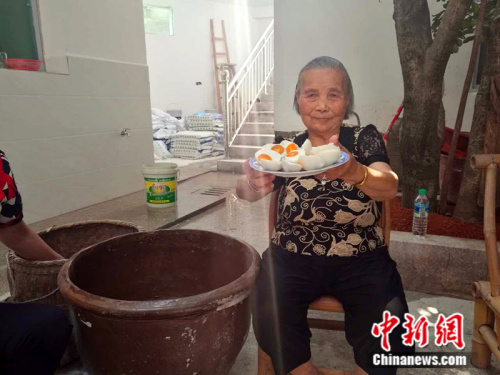 凤岗村村民廖奶奶向记者展示当合作社腌制的咸鸭蛋。 中新网记者 张尼 摄
