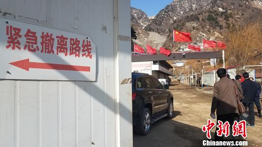 图为3月25日，秦岭金矿救援现场外围，可见安全警示标语。　王登峰 摄