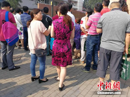 6月7日，人大附中考场外，一名家长身着旗袍送考。 中新网记者 张尼 摄