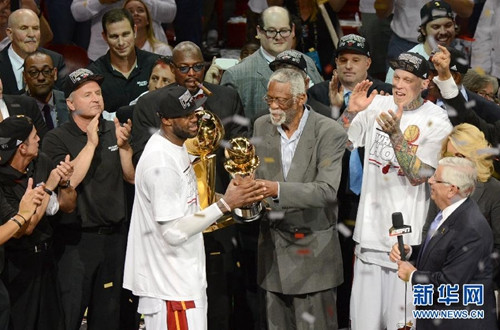 资料图：以NBA传奇名宿的身份，比尔拉塞尔为勒布朗-詹姆斯颁发总决赛最有价值球员奖杯。图片来源：新华网