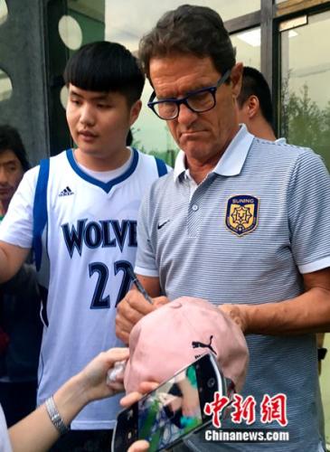 卡佩罗为球迷签名。中新网记者王牧青摄
