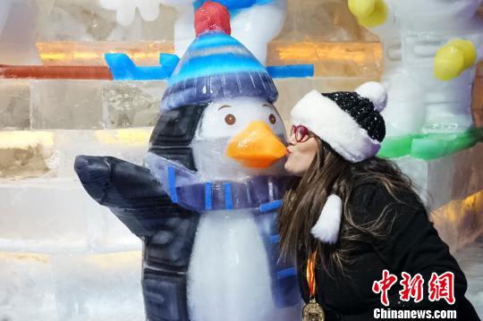 1月15日晚，北京延庆第30届龙庆峡冰灯艺术节开幕。图为游客与冰灯作品合影留念。　熊然 摄